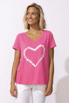 Woman wearing a pink t-shirt with a white heart design on a white background