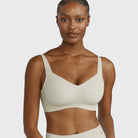 Beyond Bra in Aloe, light sage green wirefree bra on a model against a white background. 