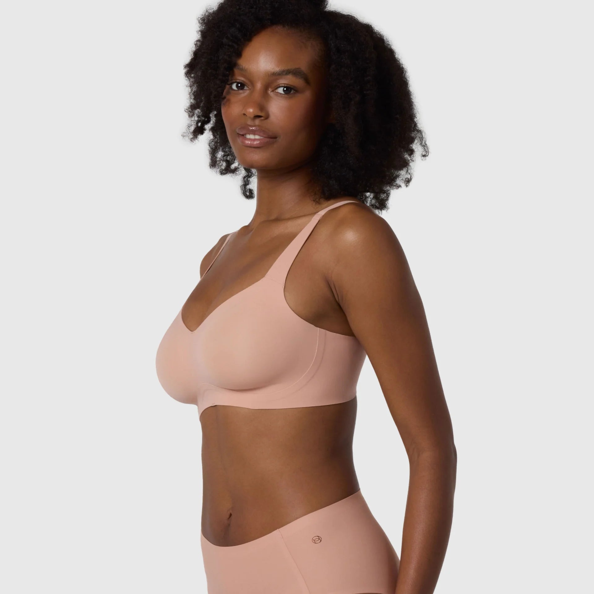 The Beyond Bra in Himalayan Salt light pinkish neutral colored wirefree bra shown on a model. 