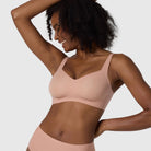 The Beyond Bra in Himalayan Salt, light pink neutral coloured wirefree bra shown on a model with her arms up to see the sides. 