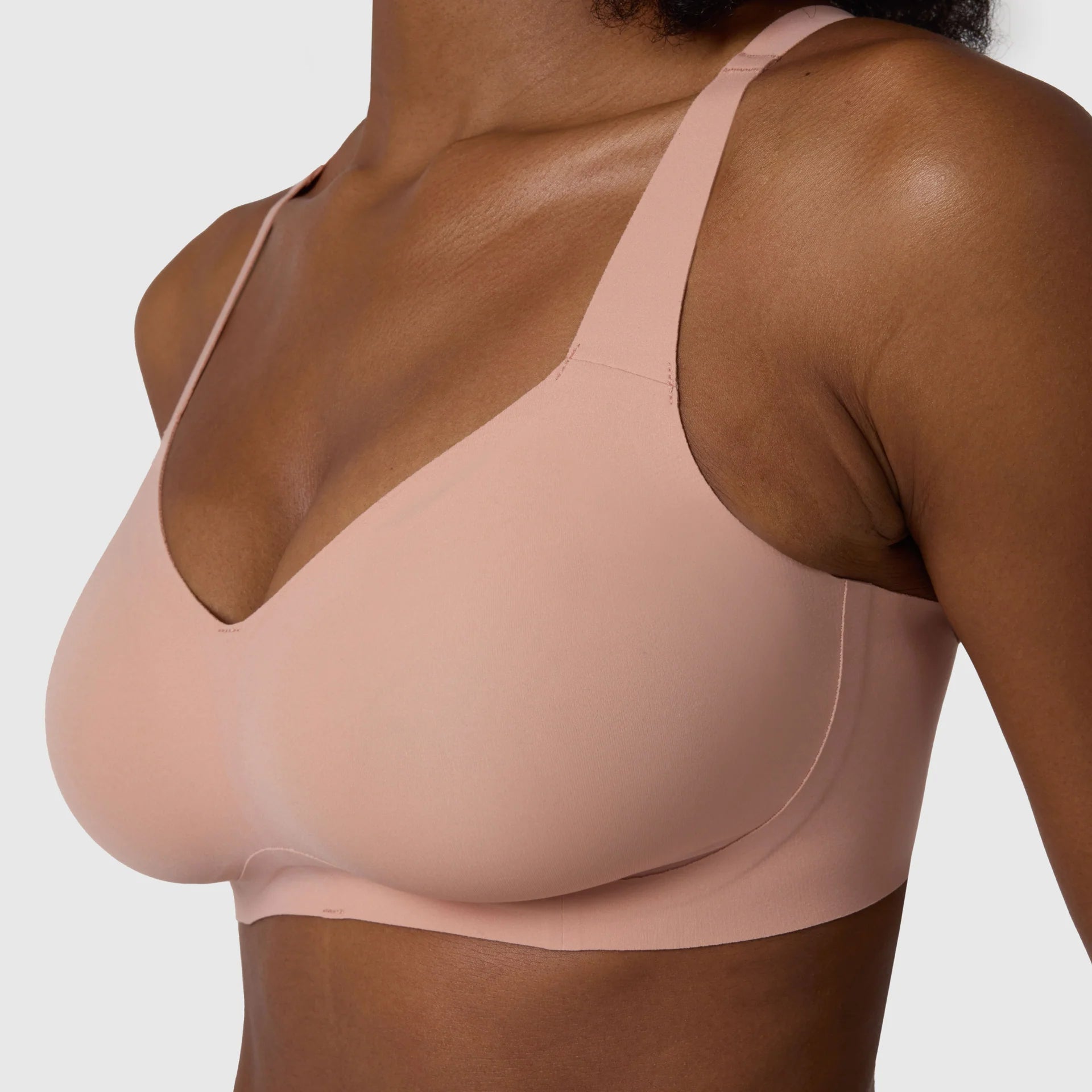 The Beyond Bra in Himalayan Salt, light pinkish neutral wirefree bra shown on a model with a close up view. 
