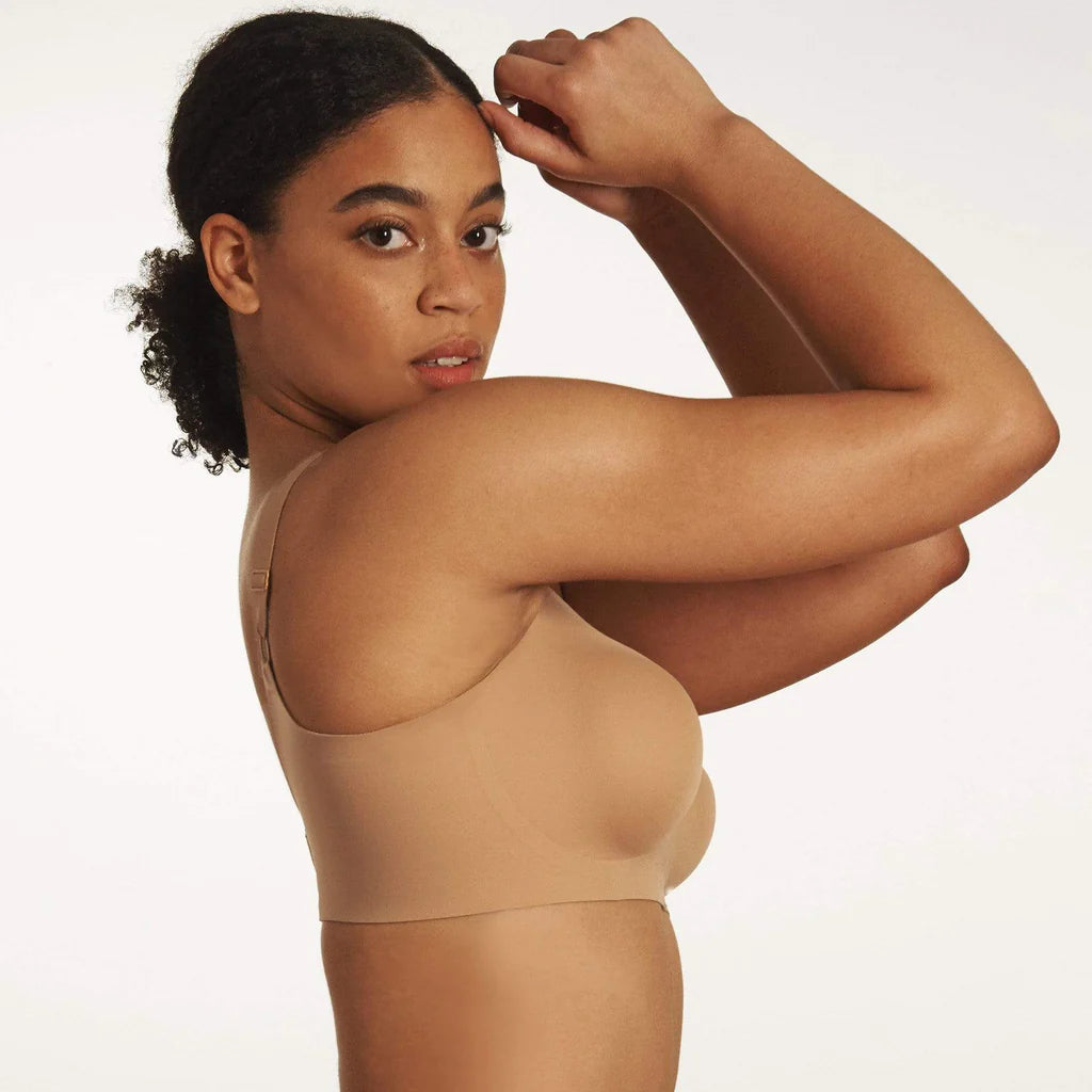 Beyond Bra in Mica, light tan wirefree bra shown on a model with her arms up so you can see the side band view. 