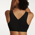 Woman wearing the Evelyn & Bobbie Defy Bra in Black, no wire pullover bra, against a white background, back view. 