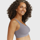 Woman wearing the Evelyn Bobbie Defy Bra in London Fog, light grey no wire bra, on a white background, side view. 