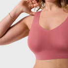 Woman wearing the Evelyn & Bobbie Defy Bra in Pink Canyon, soft pink no wire pullover bra, on a white background. 