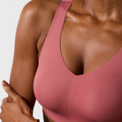 Woman wearing the Evelyn & Bobbie Defy Bra in Pink Canyon, soft pink no wire pullover bra, on a white background. 