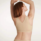 A woman wearing the Evelyn & Bobbie Defy Bra in Sand, light beige no wire bra, on a white background. 
