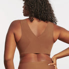 Woman wearing the Evelyn & Bobbie Evelyn Bra in Clay, brown no wire pullover bra, against a white background, back view. 