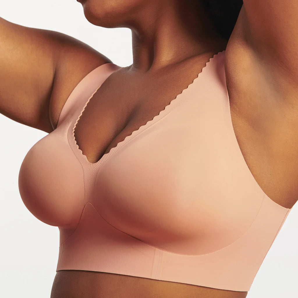 Woman wearing Evelyn & Bobbie Evelyn Bra in Himalayan Salt, light pink no wire pullover bra, against a white background, front view. 