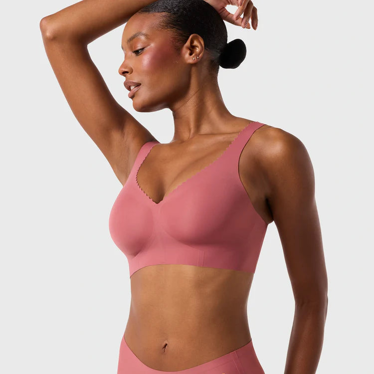 Woman wearing the Evelyn & Bobbie Evelyn Bra in Pink Canyon, dusty pink no wire pullover bra, on a white background, front view. 