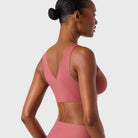 Woman wearing the Evelyn & Bobbie Evelyn Bra in Pink Canyon, dusty pink no wire pullover bra, on a white background, back view. 