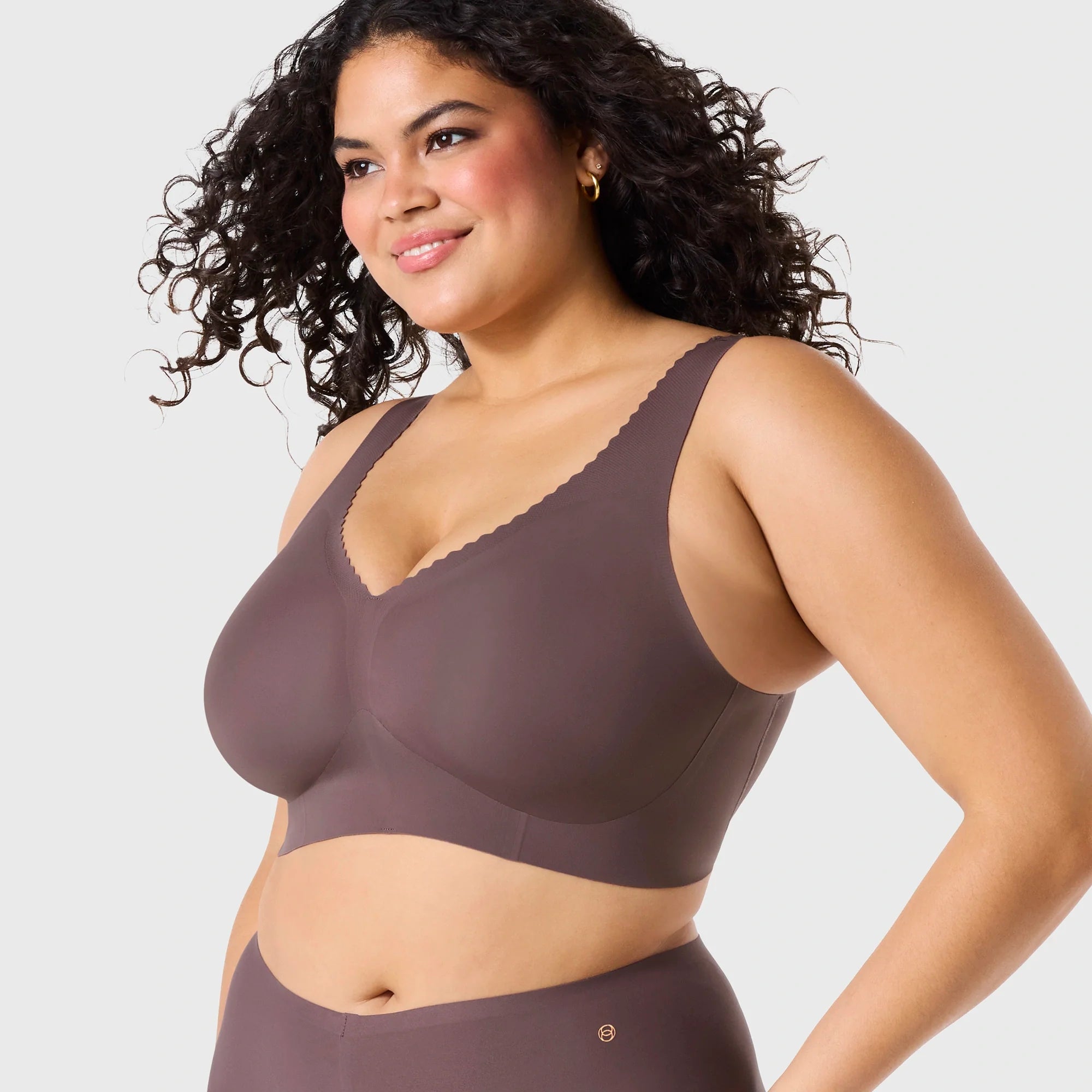 Woman wearing Evelyn & Bobbie Evelyn Bra in Thistle, dark mauve no wire pullover bra, against a white background, front view. 