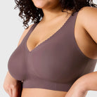 Woman wearing Evelyn & Bobbie Evelyn Bra in Thistle, dark mauve no wire pullover bra, against a white background, front view. 