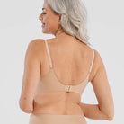 Woman wearing the Evelyn & Bobbie Starlette Bra in Sand, beige no wire bra, against a white background, back view. 