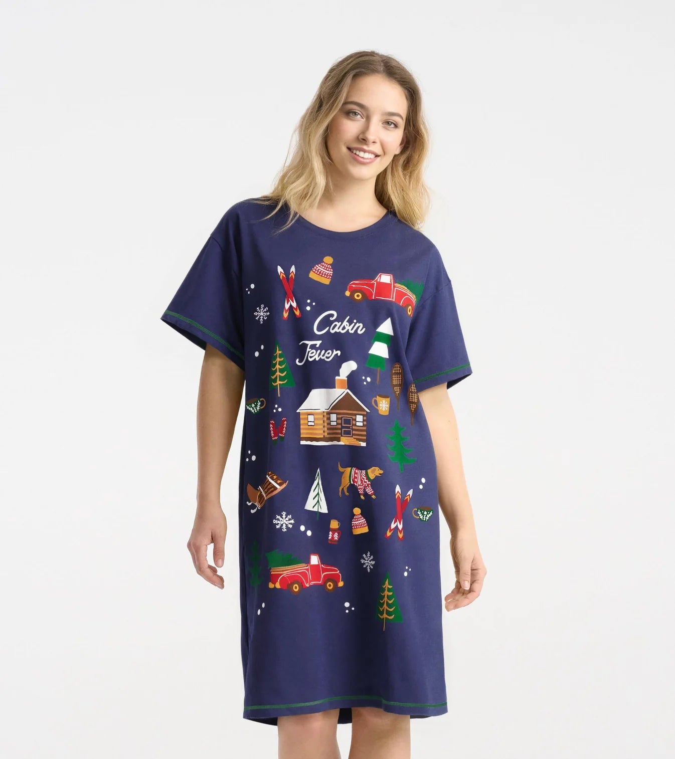 Woman wearing a navy blue nightshirt with cabin-themed graphics on a white background