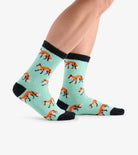 Teal socks with fox pattern worn by a person on a white background