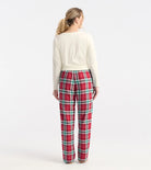 Person wearing red plaid pants and a white top on a white background