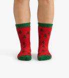 Red socks with green accents and tree patterns worn by a person on a white background