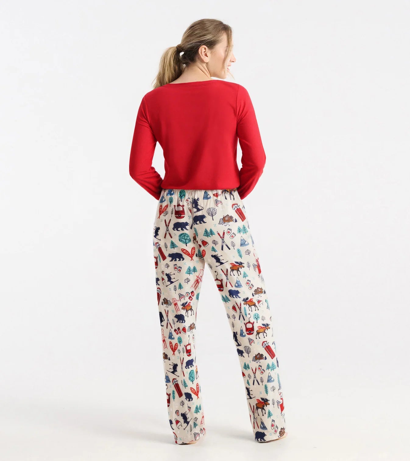 Woman wearing a red top and patterned pants on a white background