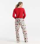 Woman wearing a red top and patterned pants on a white background