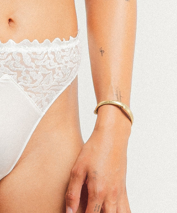 White lace underwear worn by a person on a plain background