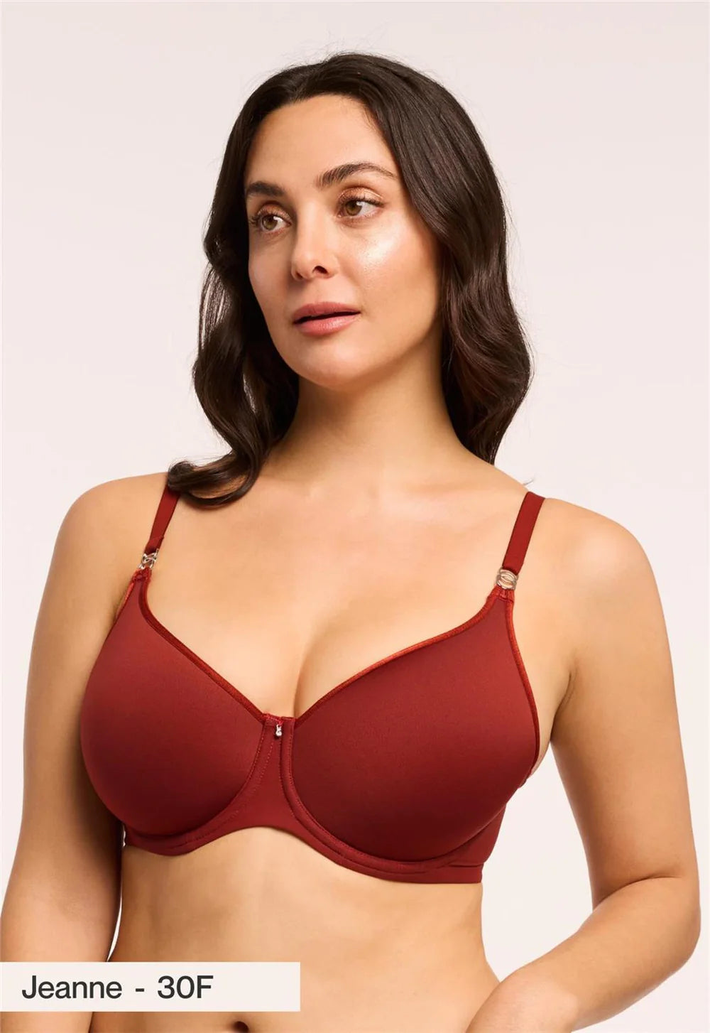 Woman wearing a red bra against a plain background