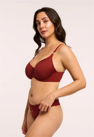 Woman wearing a red bra and panties set on a plain background