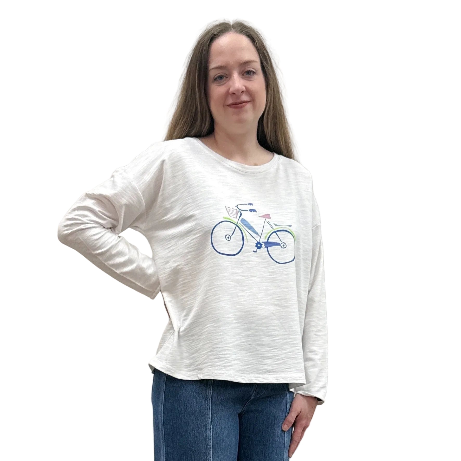 Person wearing a white long-sleeve Papa Bicycle Pullover shirt and blue jeans standing on a white background. 