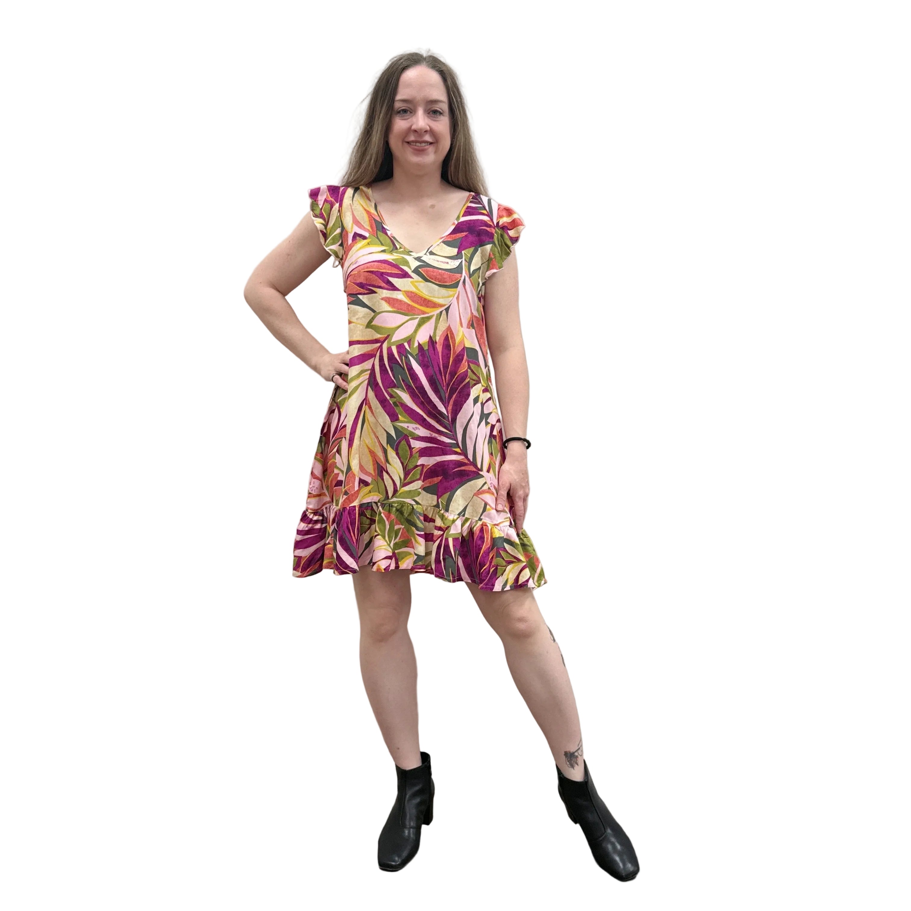 Woman wearing a colorful floral Papa Classic Print dress in Pink against a plain wall.