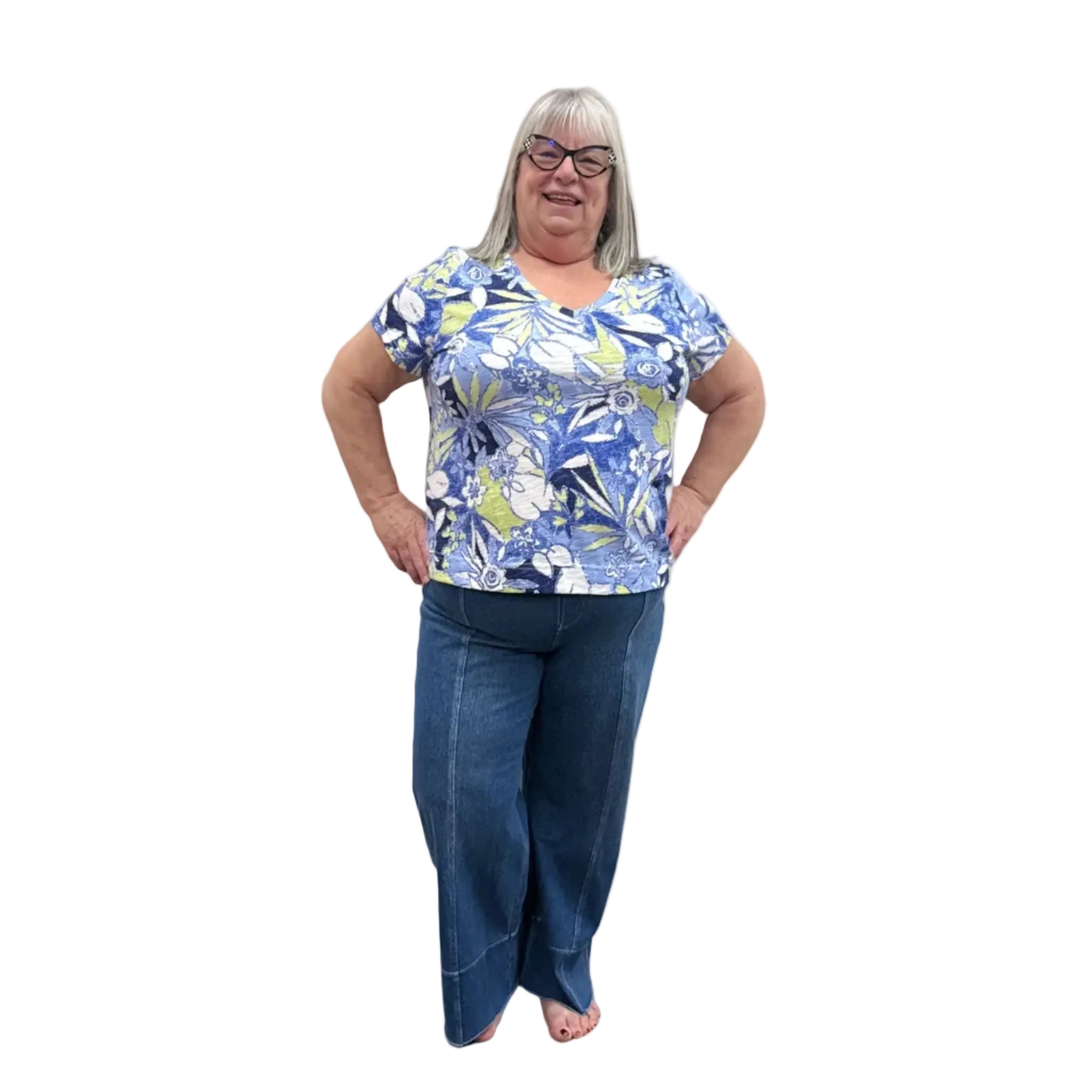 Person wearing a blue floral top and blue Papa Comfort Crop jeans standing against a plain wall, front view. 