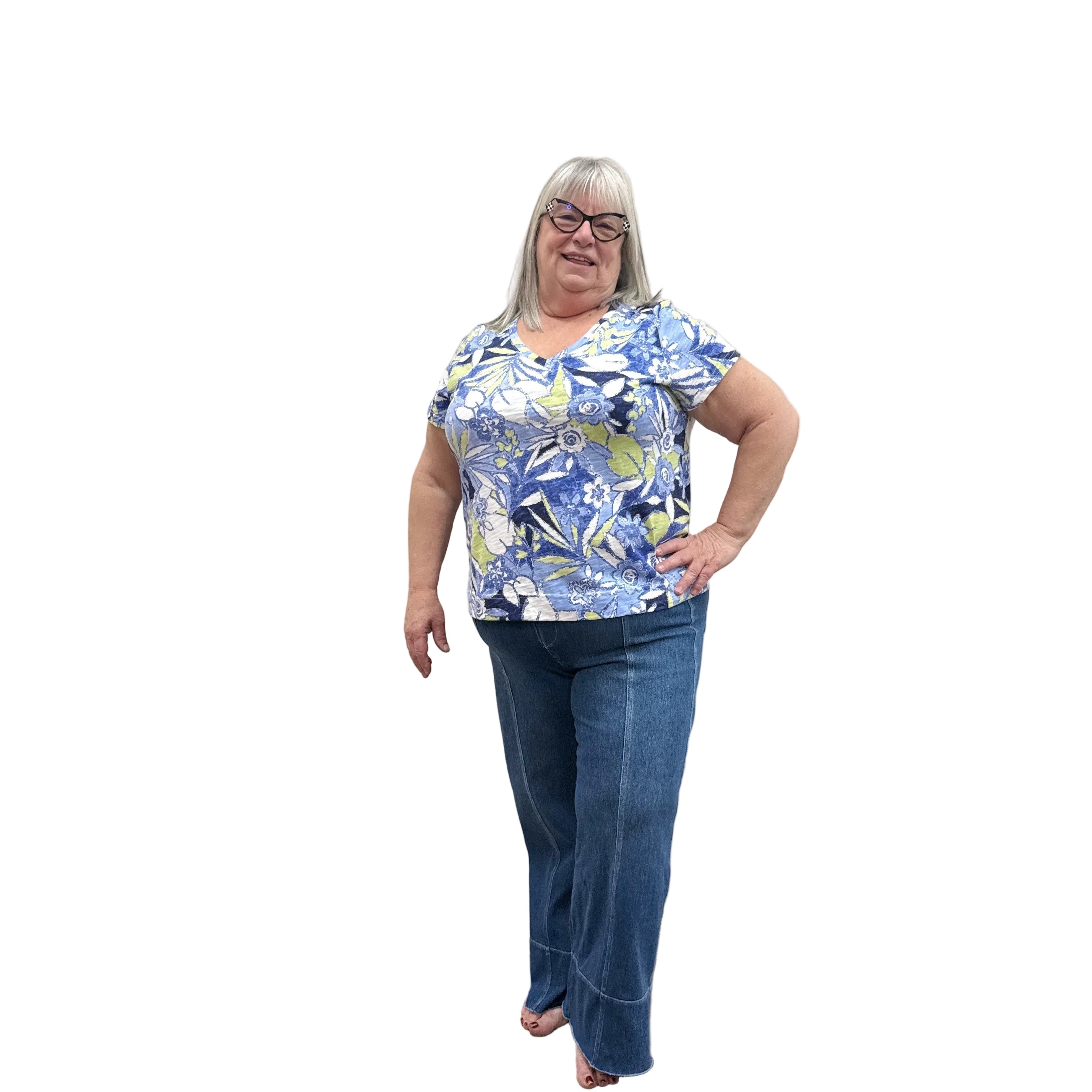Person wearing a blue floral top and blue Papa Comfort Crop jeans standing against a plain wall, front view. 
