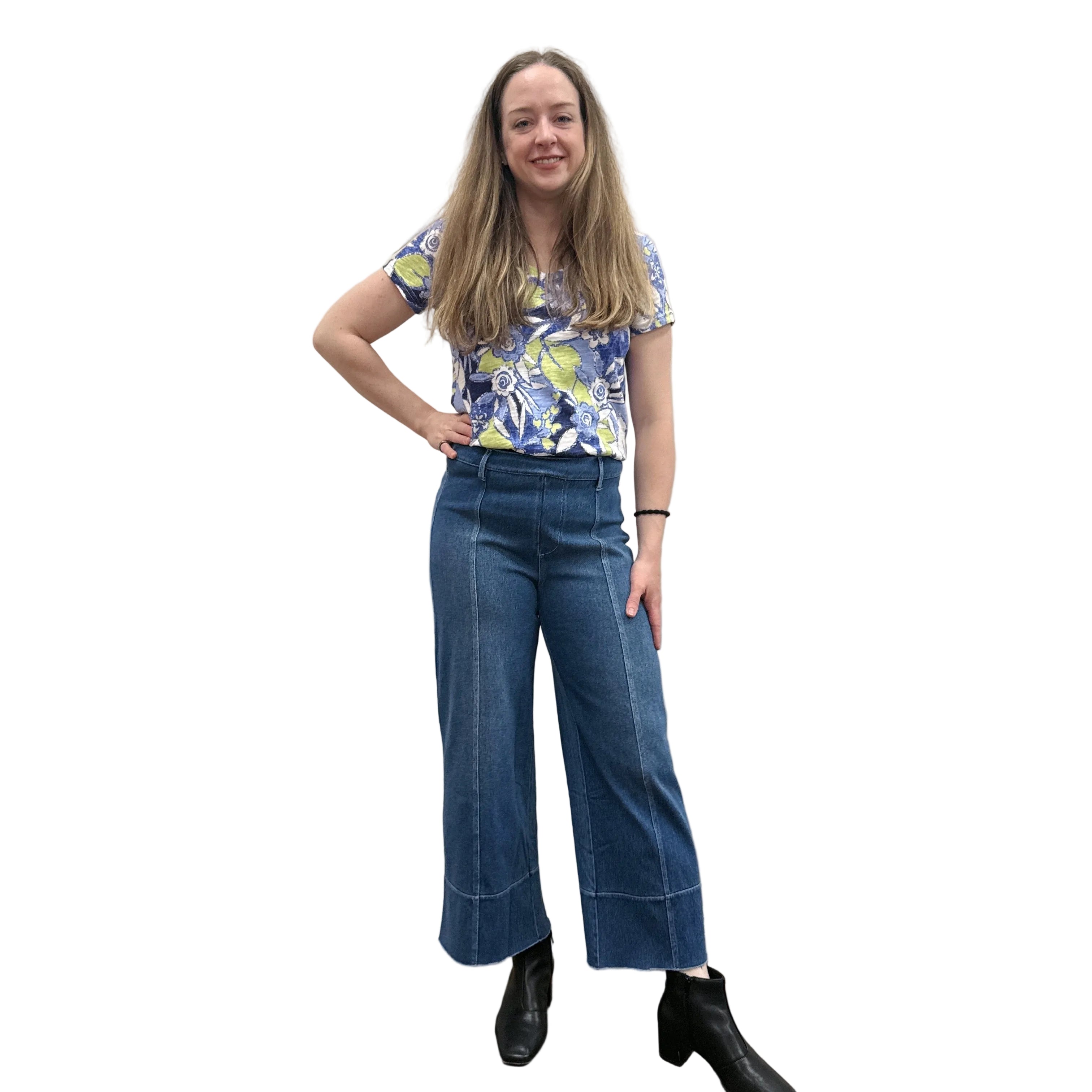 Person wearing a blue floral top and blue Papa Comfort Crop jeans standing against a plain wall, front view. 