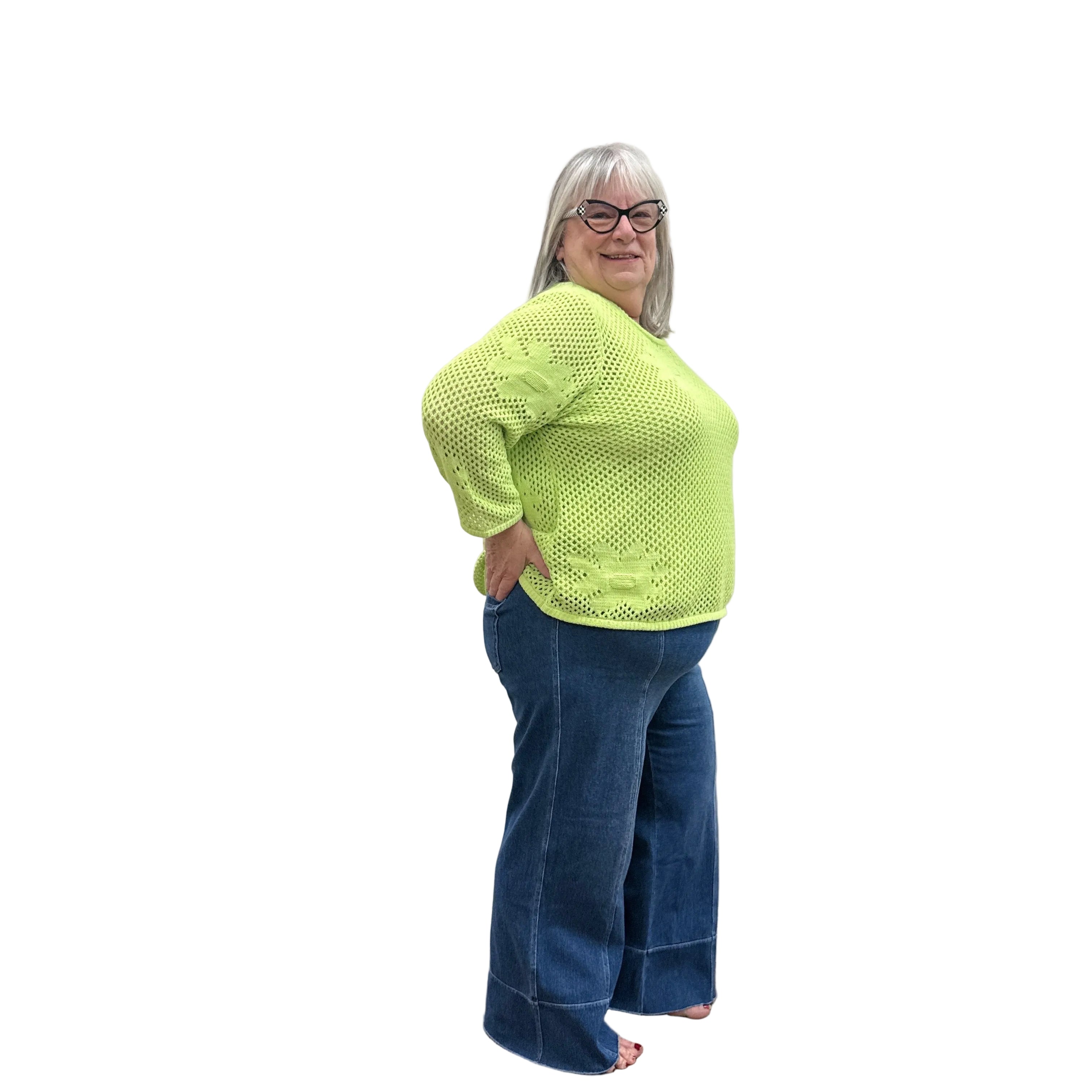 Person wearing a bright green Papa Easy Pullover sweater and blue jeans standing against a plain wall.