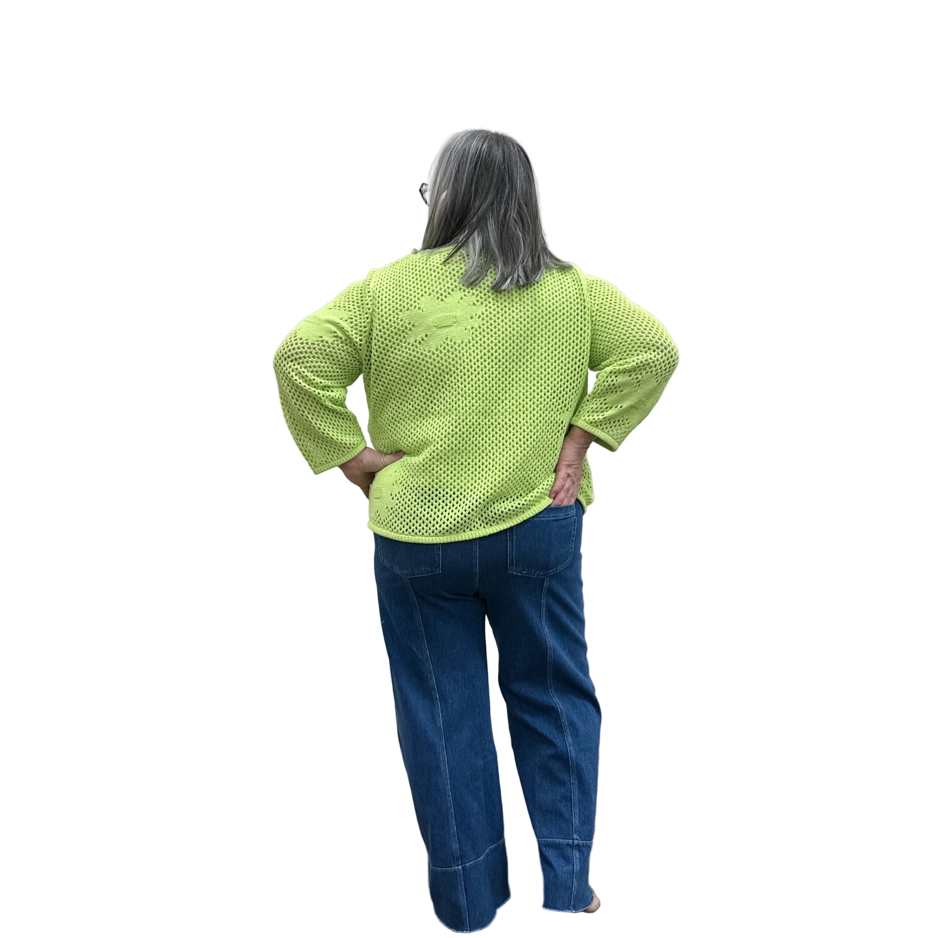 Person wearing a bright green Papa Easy Pullover sweater and blue jeans standing against a plain wall.