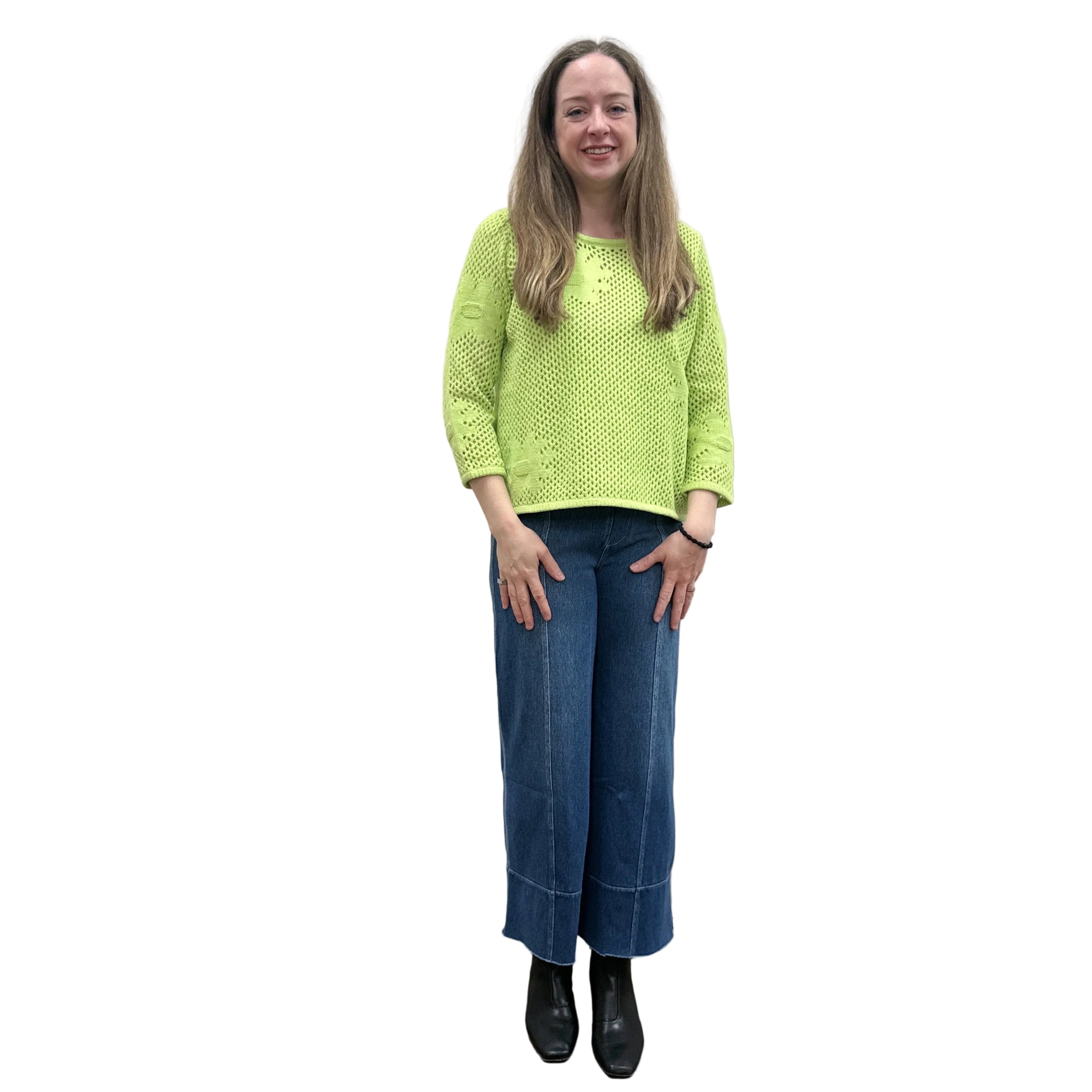 Person wearing a bright green Papa Easy Pullover sweater and blue jeans standing against a plain wall.