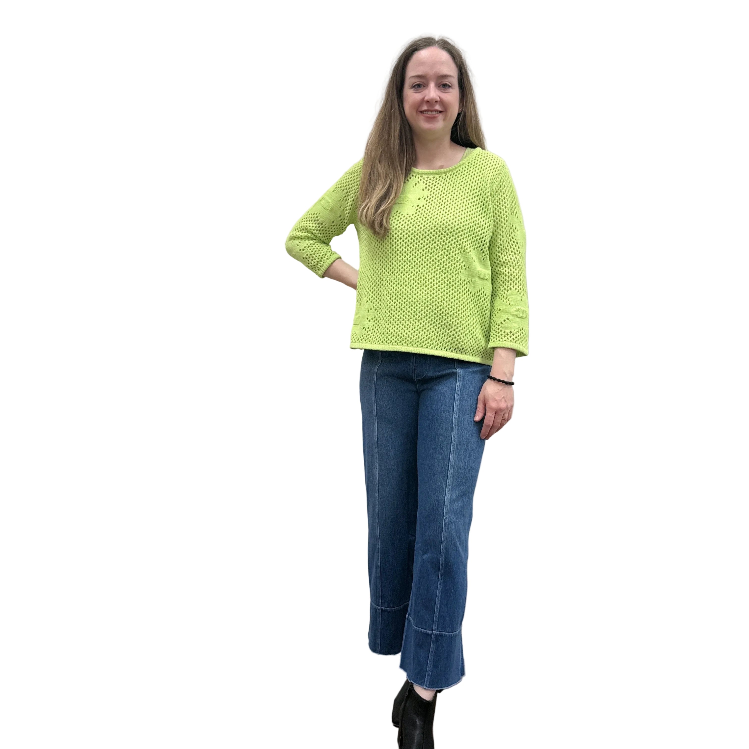 Person wearing a bright green Papa Easy Pullover sweater and blue jeans standing against a plain wall.
