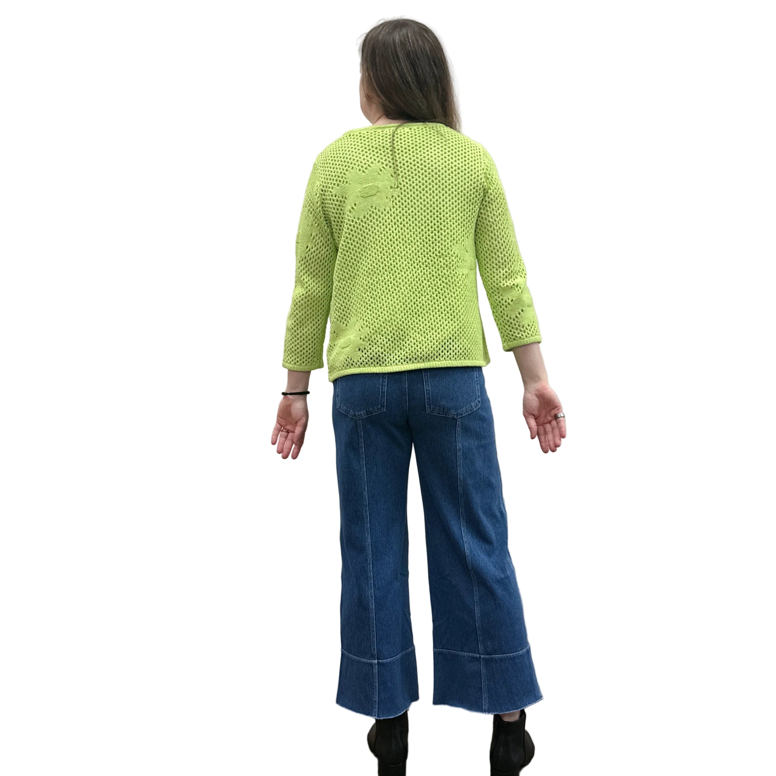 Person wearing a bright green Papa Easy Pullover sweater and blue jeans standing against a plain wall.