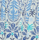 Woman wearing a sleeveless dress with a blue floral pattern on a white background