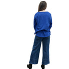 Person wearing a blue Papa High Low longsleeve top and jeans on a white background. 