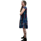 Woman wearing the Papa Indigo Mosaic Breeze patterned dress against a white background, side view. 