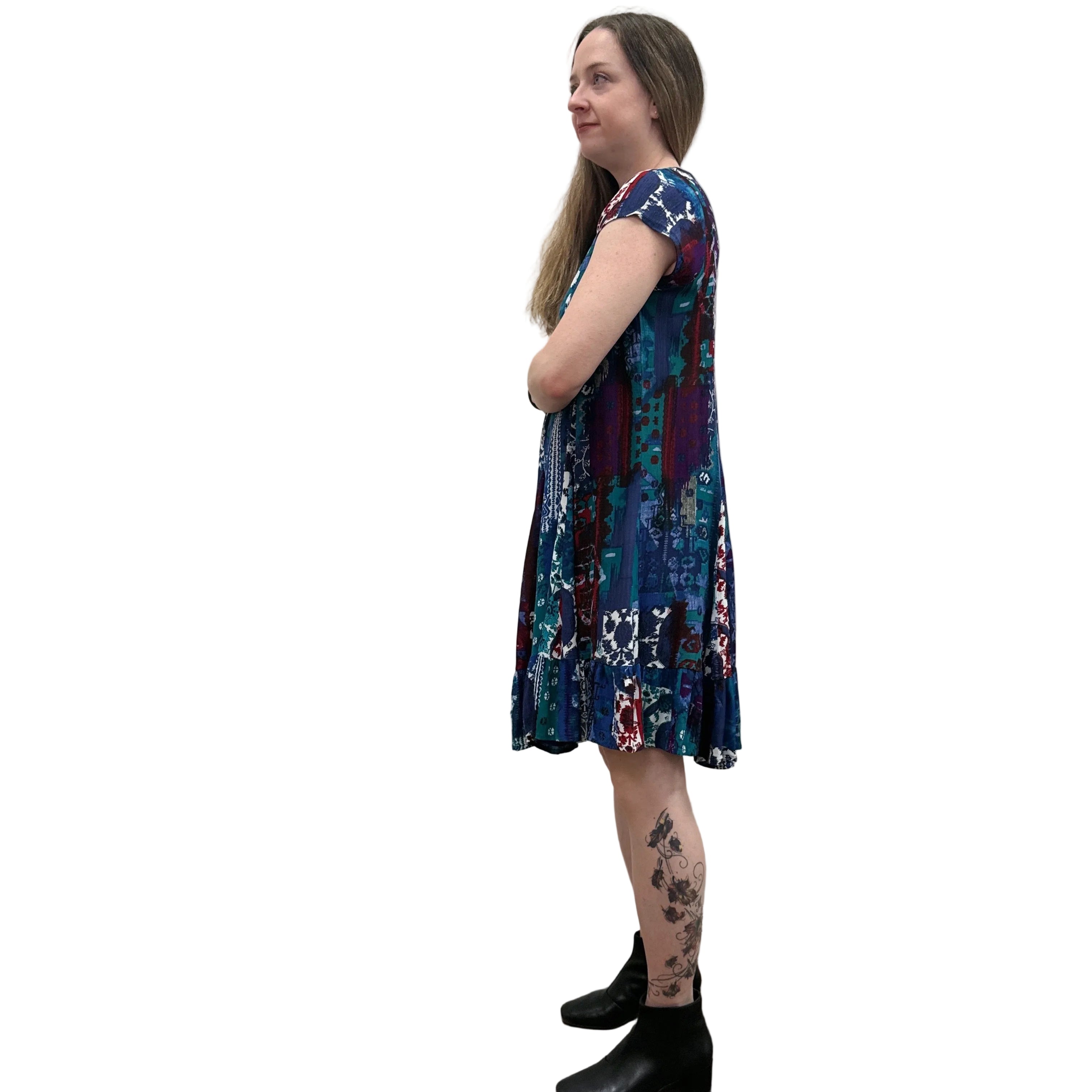 Woman wearing the Papa Indigo Mosaic Breeze patterned dress against a white background, side view. 