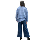 Person wearing a blue Papa Weekend Pullover sweater and jeans standing against a plain wall.