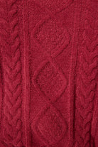 Close-up of a red knitted fabric with cable pattern