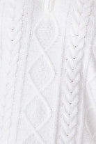 Close-up of a textured white fabric with cable knit pattern