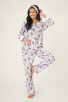Woman wearing a floral pajama set on a plain background