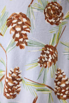 Pattern of pine cones and branches on a light blue background