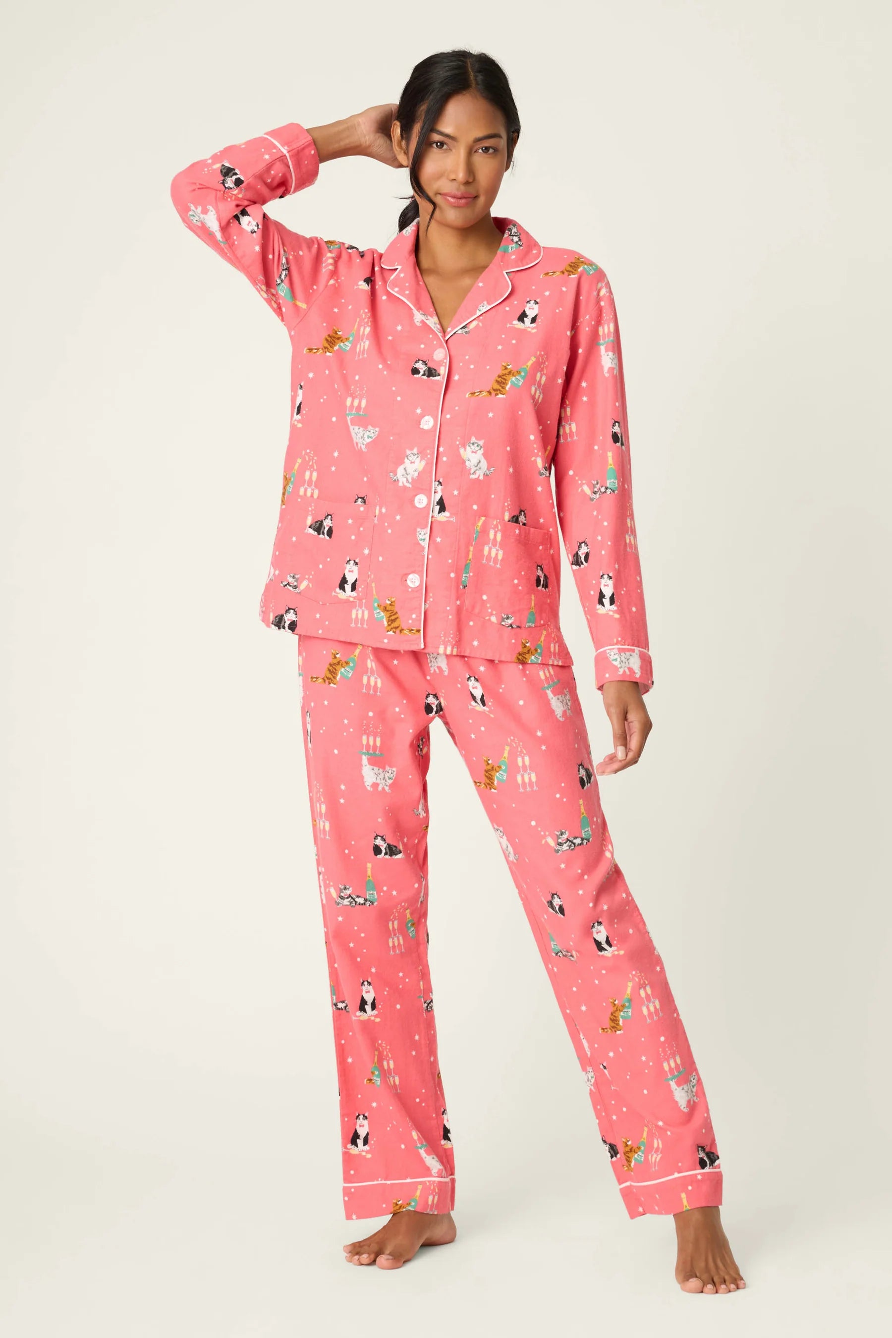 Woman wearing pink pajamas with animal print on a white background
