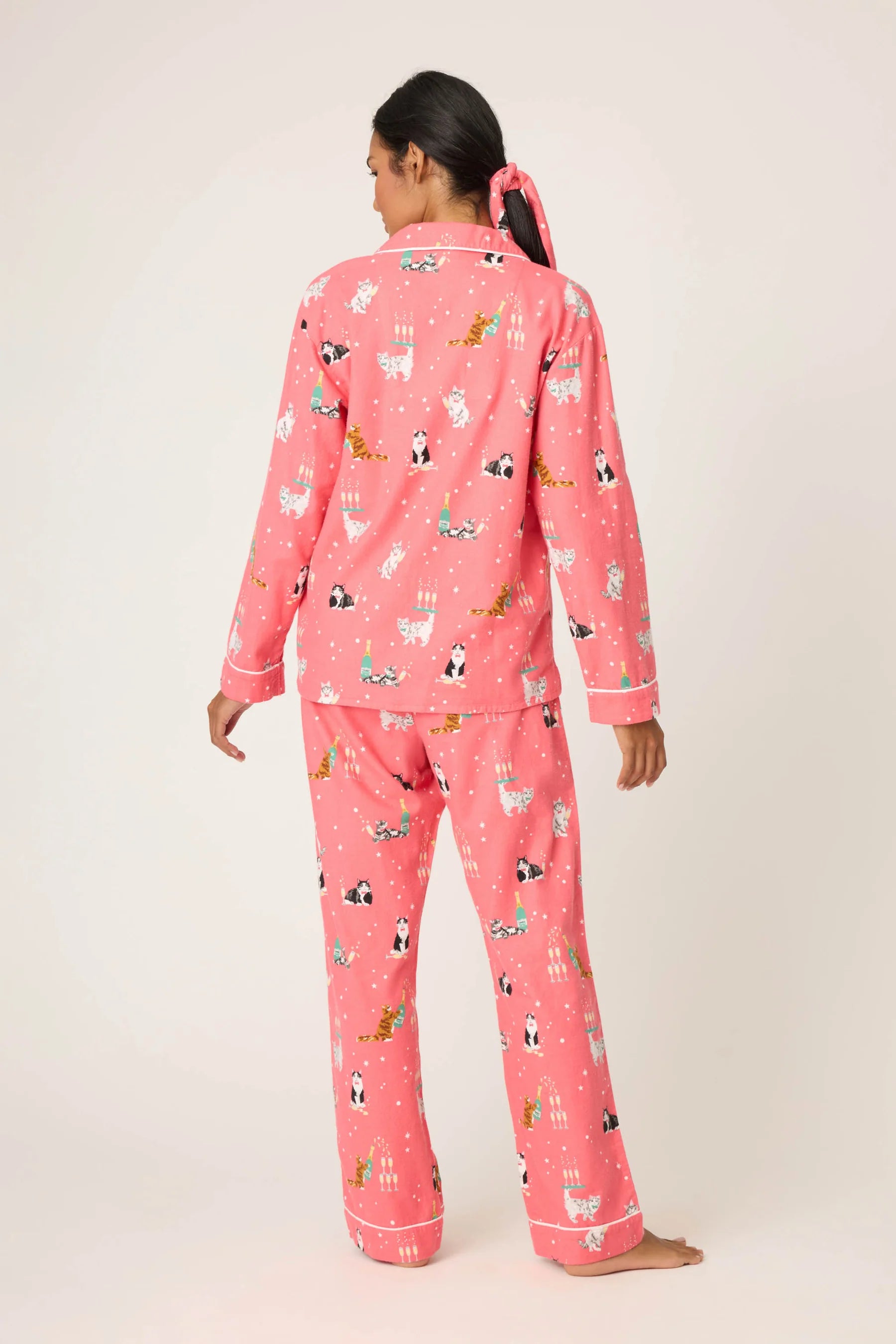 Person wearing pink pajamas with animal print on a white background
