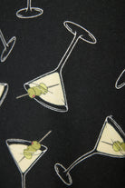 Close up of a black fabric swatch with martini glasses with olives