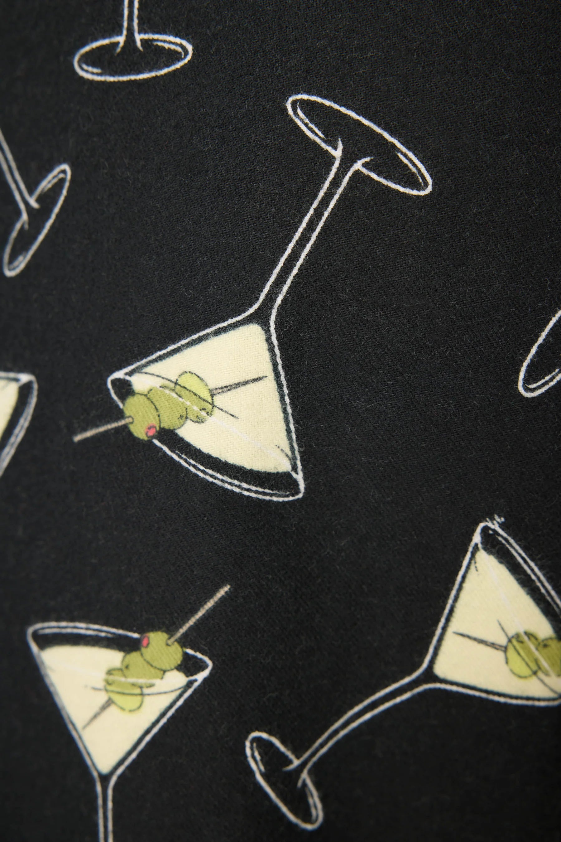 Close up of a black fabric swatch with martini glasses with olives
